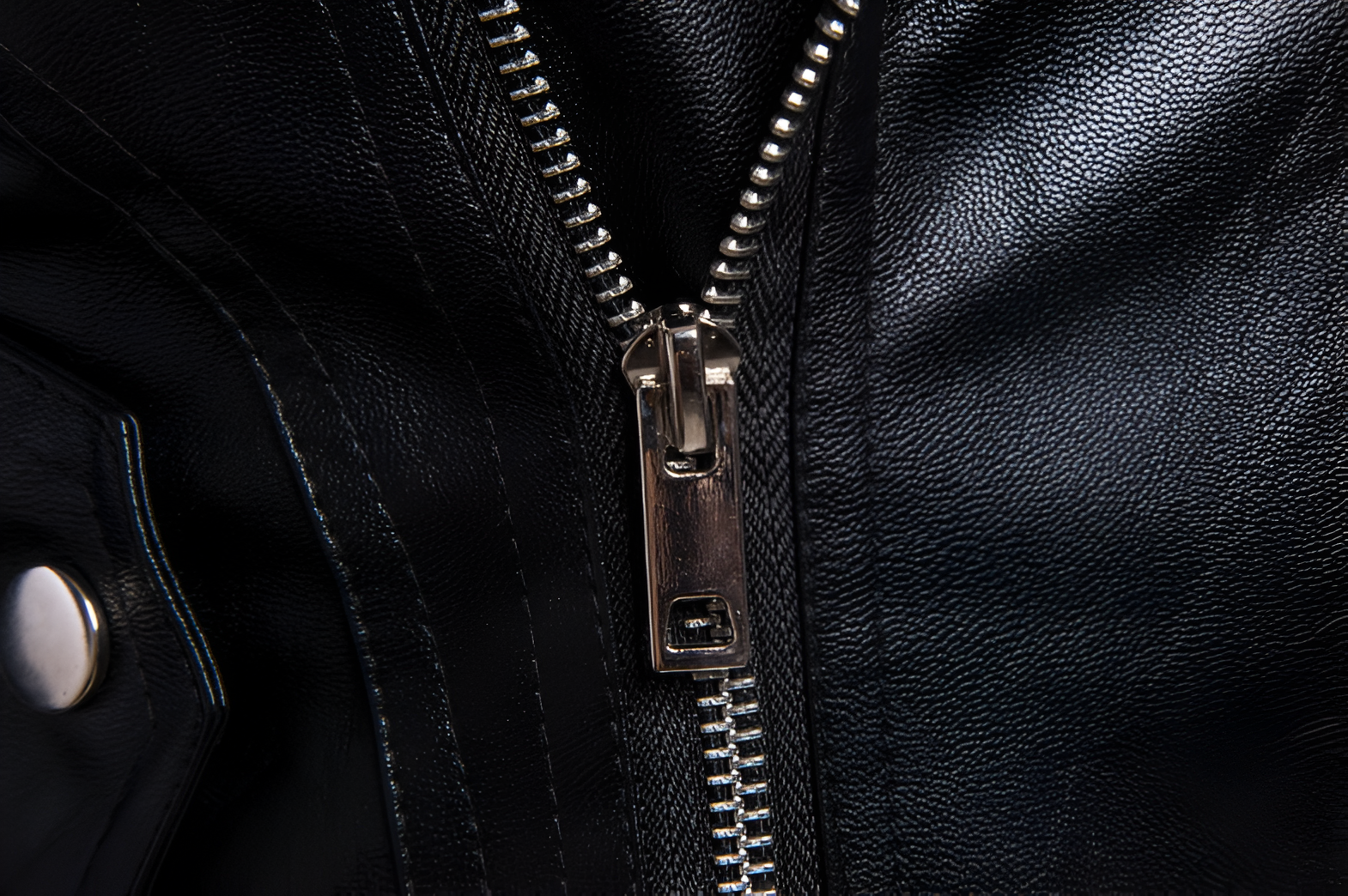 Detalle de corredera y cierres metálicos en chaleco rockero estilo biker